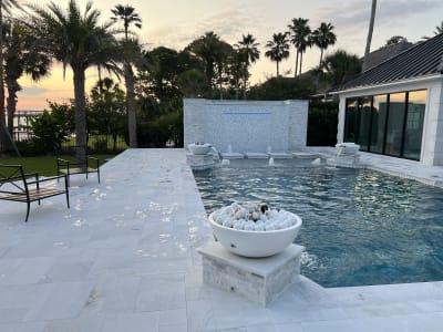 Luxury in-ground pool with spa, pergola, sheer descent, and tanning ledge at the Sheldon Residence in Miramar Beach, FL.