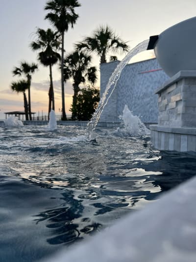Luxury pool with central water fountain feature and multiple jets at the Sheldon Residence in Miramar Beach, FL.