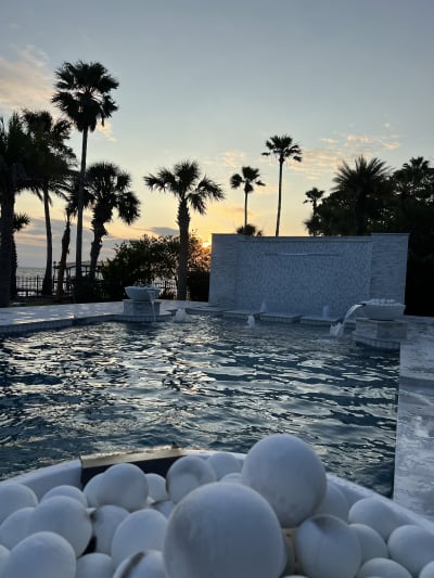 Luxury swimming pool with water features and sunset views at the Sheldon Residence in Miramar Beach, FL.