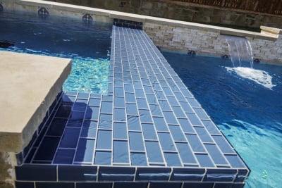 Hero view of a blue glass tile pool crafted for a Fort Worth, Tarrant County, TX outdoor living space, showcasing Selah Pools' architectural design rigor and design-build methodology.