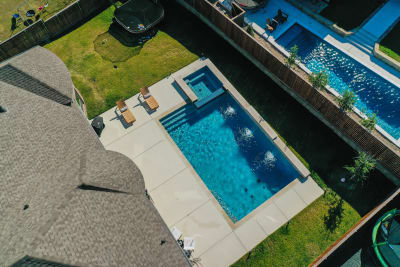 Aerial view of a custom outdoor living space with lawn furniture and manicured grounds at a Fort Worth, TX estate.