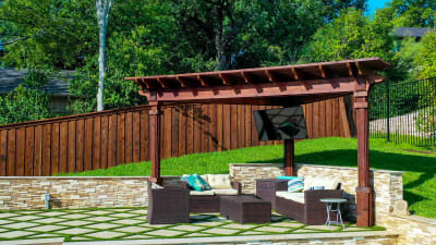 Material-detail view of travertine and granite coping alongside stone veneer raised beam and tile veneer spa surround at a family resort pool in Irving, Dallas County, TX.