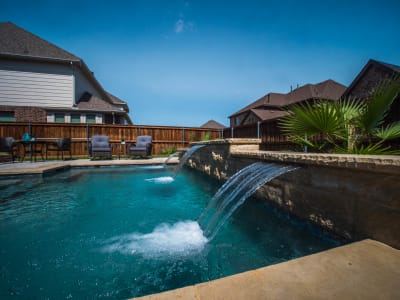 Close material-detail view of a custom square spa with stone surround and tile finish, built for evening relaxation at a Mansfield, Tarrant County, TX residence.