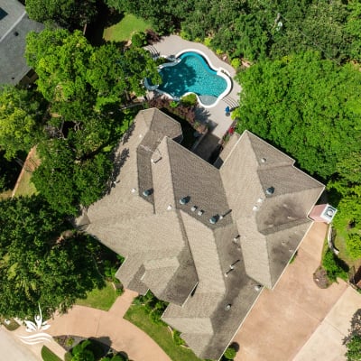 Close detail of the raised spa spillway with Burlington Carra White travertine ledgestone veneer and NPT Caribbean Mosaic tile in a Grapevine, TX outdoor living space.