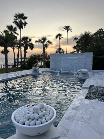 Outdoor swimming pool and spa at sunset at the Sheldon Residence in Miramar Beach, FL, by Aquatic Consultants, Inc.