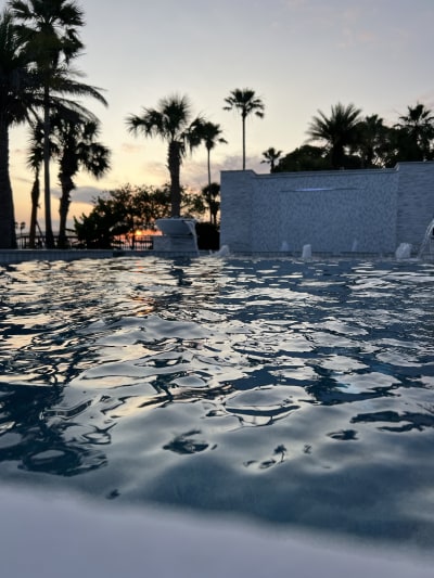 Luxury pool at sunset in Miramar Beach, FL, featuring crystal-clear water and an elegant outdoor living space.