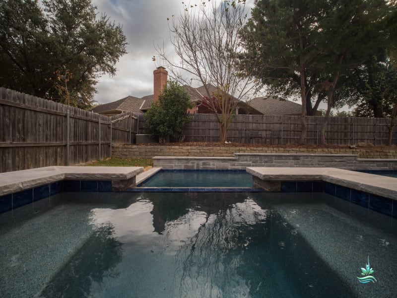 Blue glass tile pool with clean architectural lines and thoughtful proportions crafted for a Tarrant County estate in Colleyville, TX.