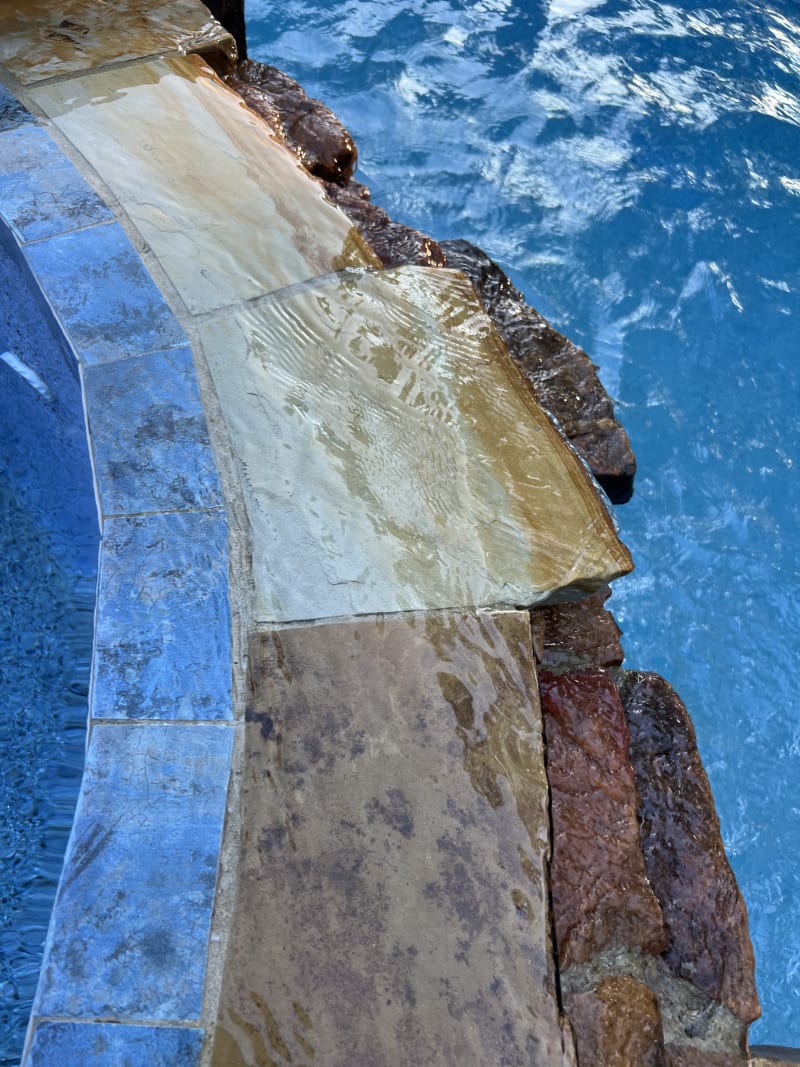 Sheer descent waterfall and raised beam pool with tanning ledge in Santa Rosa Beach, FL, featuring stone and brick deck.