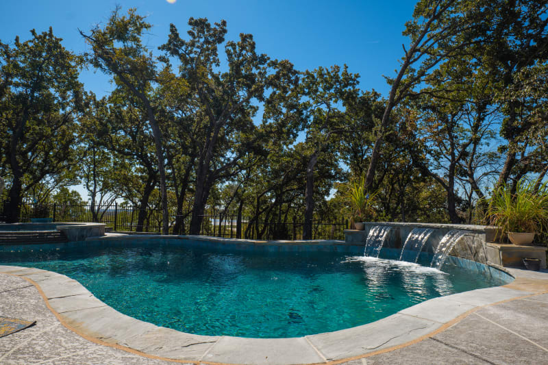 A stunning outdoor kitchen in Corinth, TX showcases a 38" Brahma 5-Burner Grill, XL LP Pizza Oven Head, and Door/Drawer Combo storage, with stainless steel appliances and S/S Double Doors.