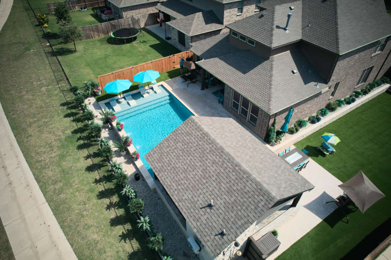 Natural lighting reveals the stunning contrast between Regatta Blue pebble finish and NPT Elysium Peacock mosaic tile accents in this 15,716-gallon custom pool.