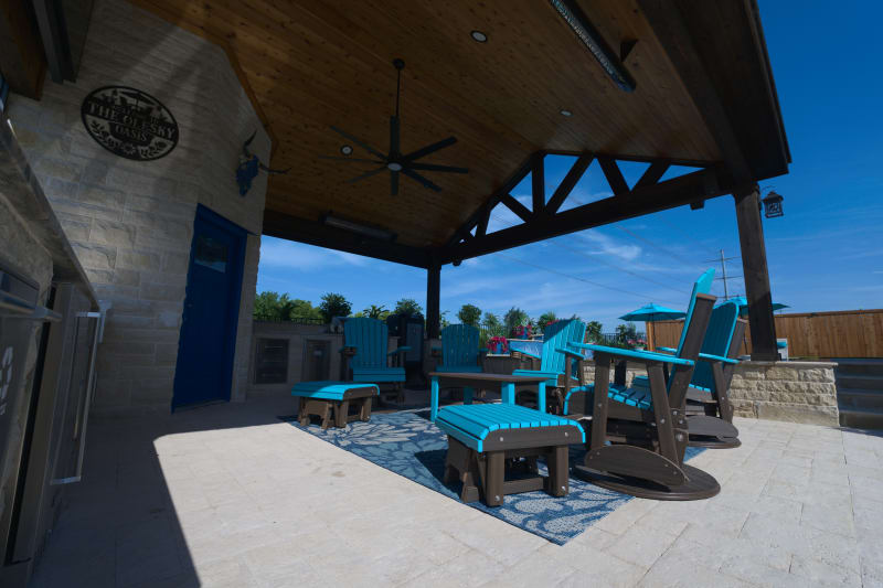 Architectural stone column transitions seamlessly into granite coping and concrete paver foundation, creating structural elegance for the Olesky covered living pavilion.