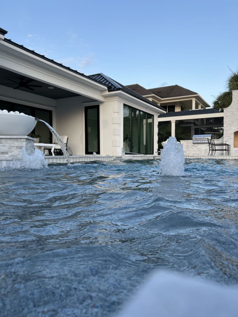 Outdoor swimming pool with elegant water features at the Sheldon Residence in Miramar Beach, FL.