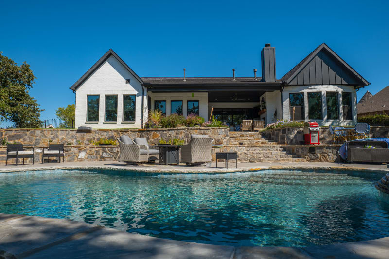 Establishing view of a complete outdoor kitchen environment at the McDaniel Residence in Corinth, TX, featuring stainless steel appliances, XL LP Pizza Oven, and 38-inch Brahma 5-Burner Grill.