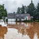 A house's exterior with a flooded yard.