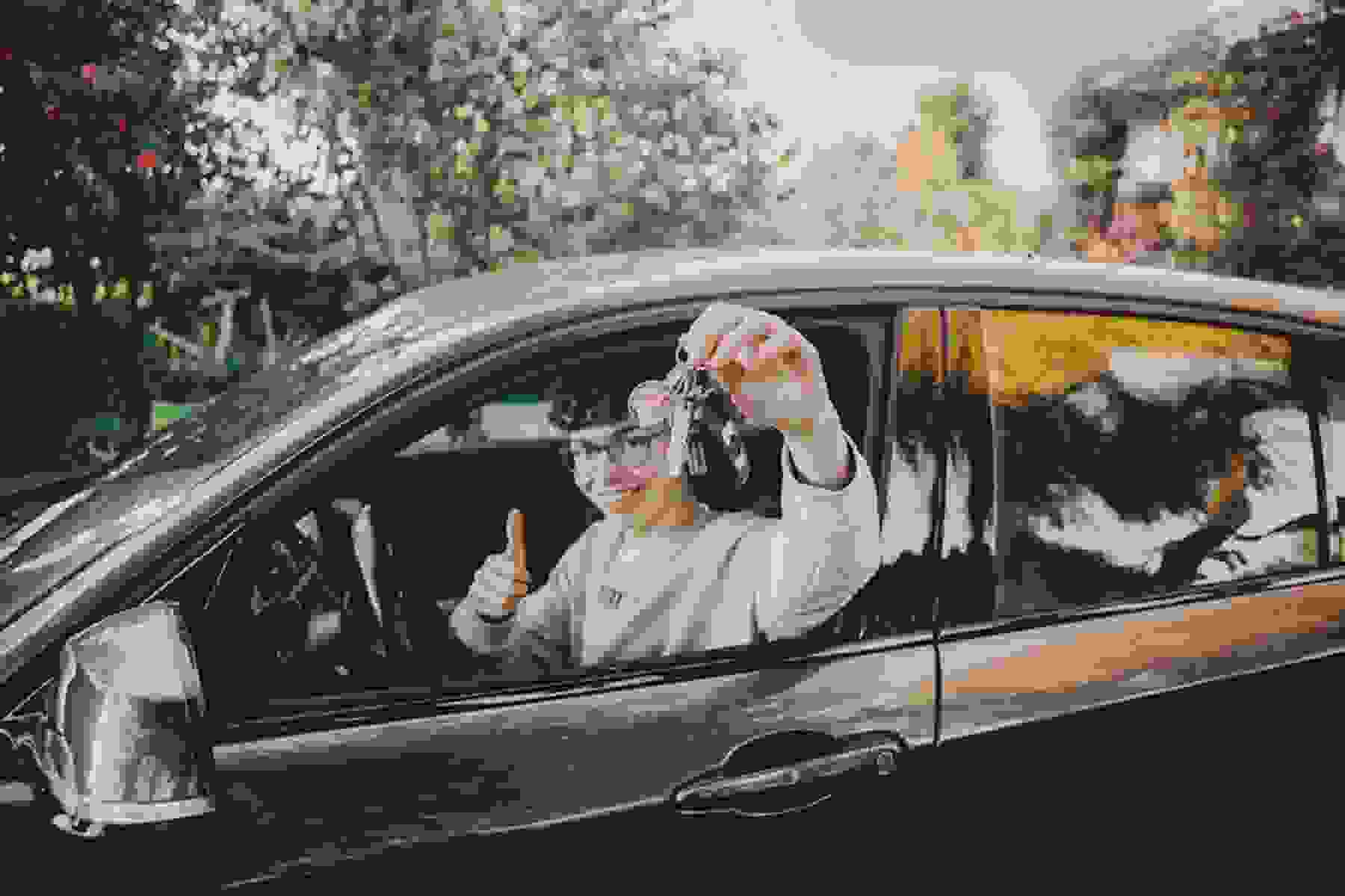 A young driver sits in his car.