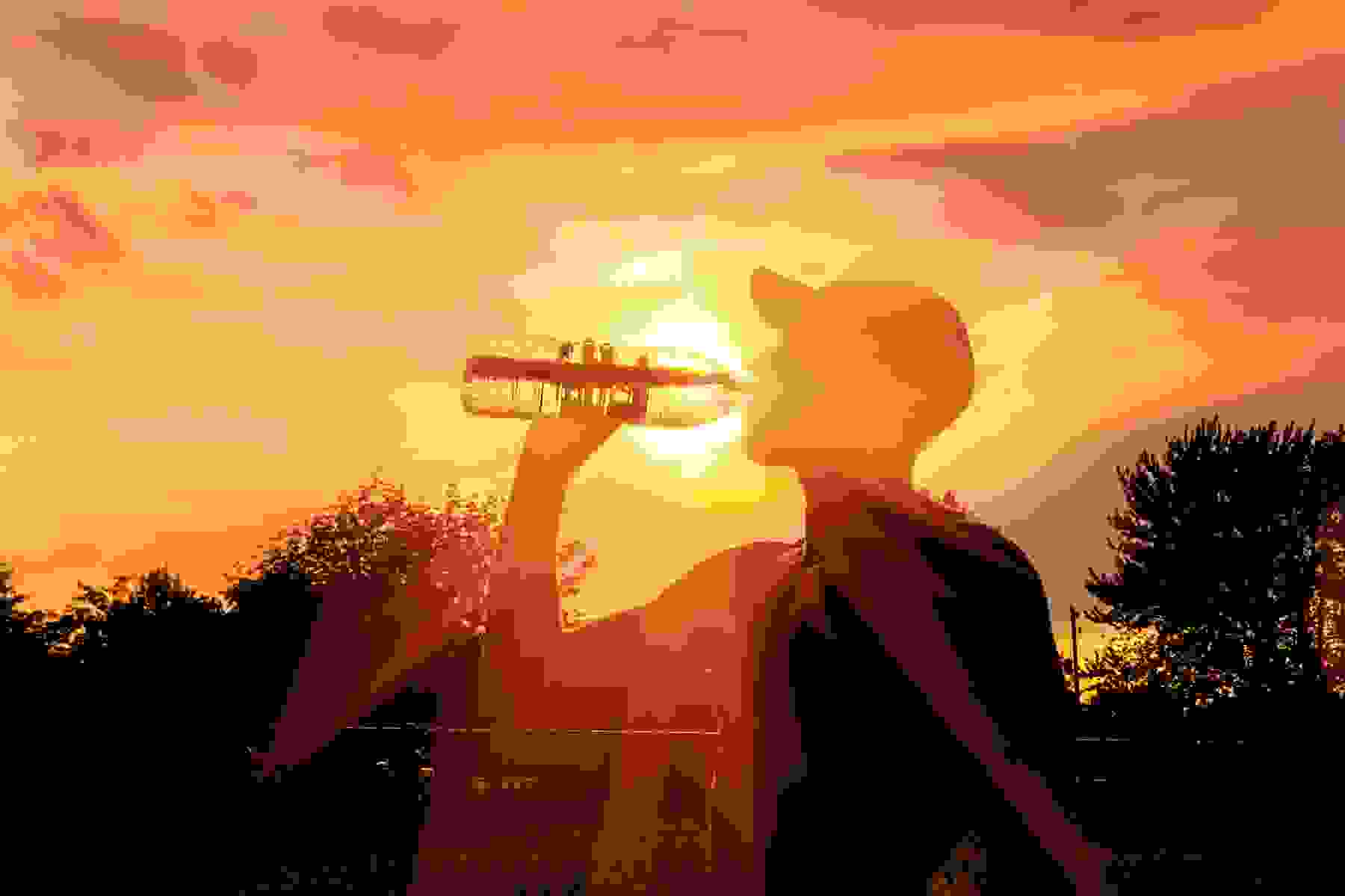 Silhouette of a man drinking water during a heat wave
