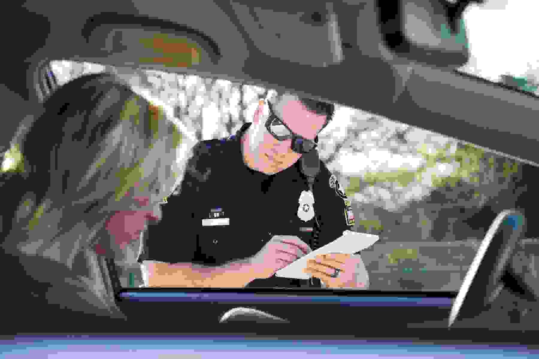 police officer writing ticket for moving violation