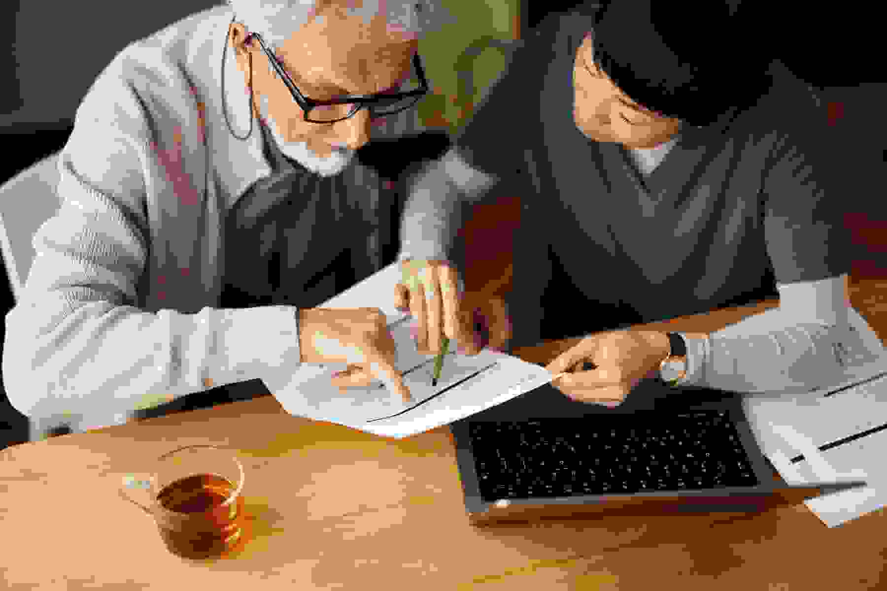 A senior man reviewing paperwork with a nurse