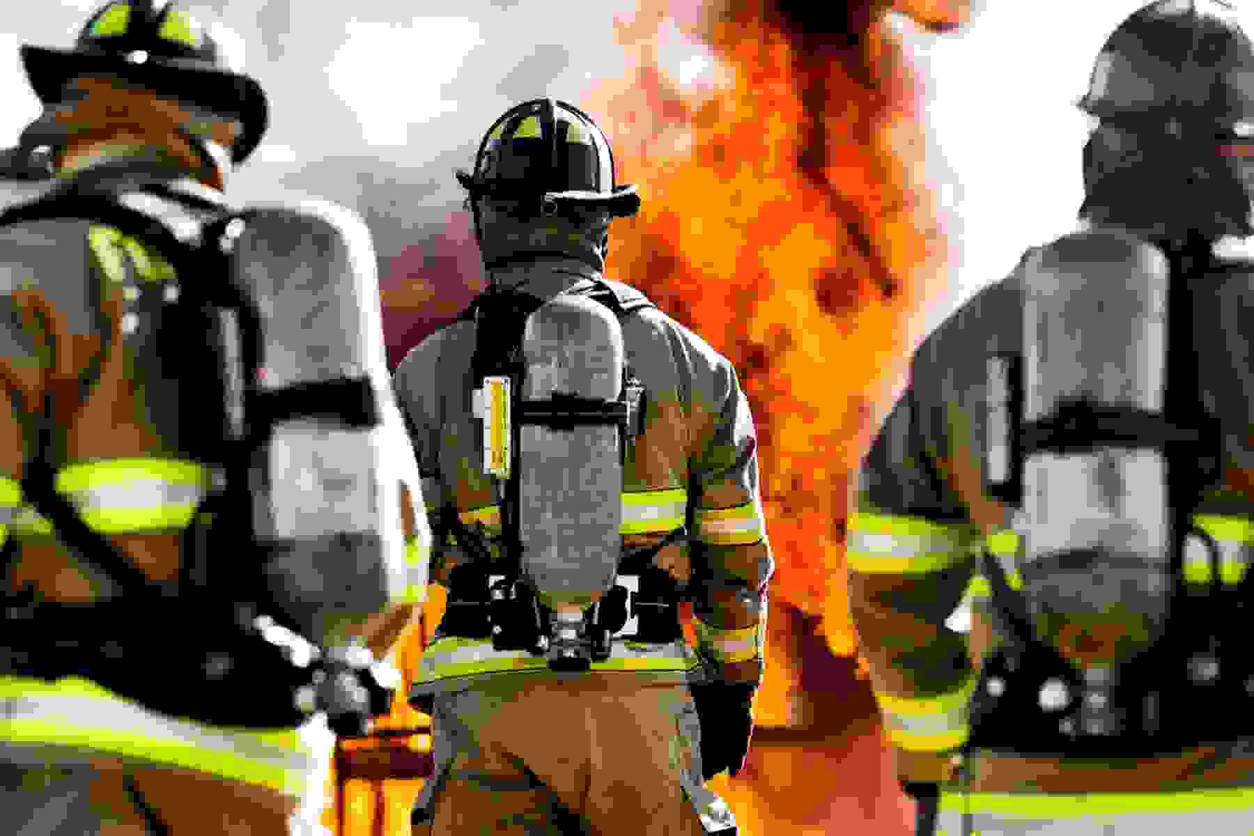Three firefighters battling flames.