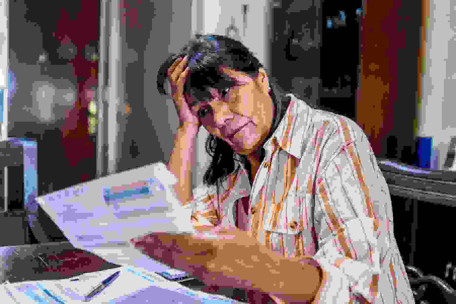 Worried woman looking at medical bills at home