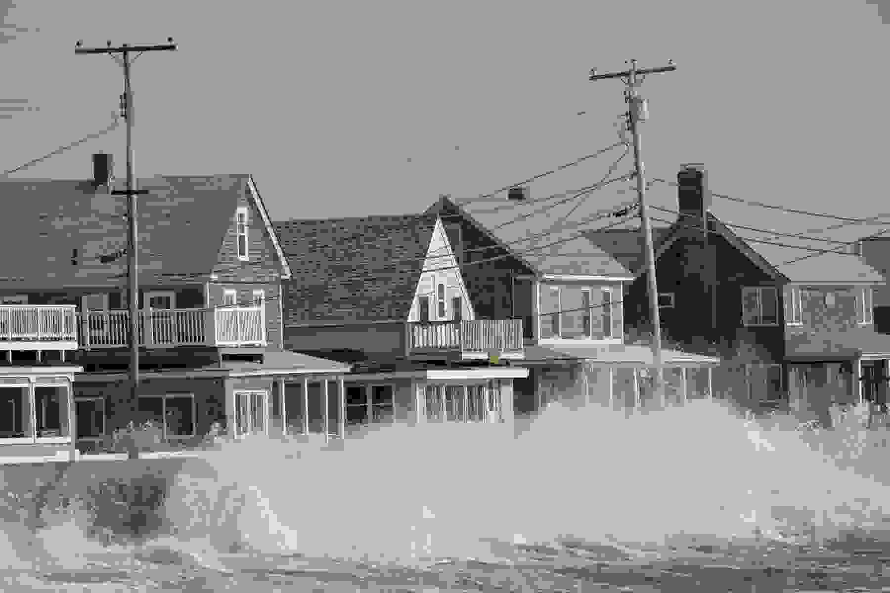 Waves strike a seawall protecting some coastal homes