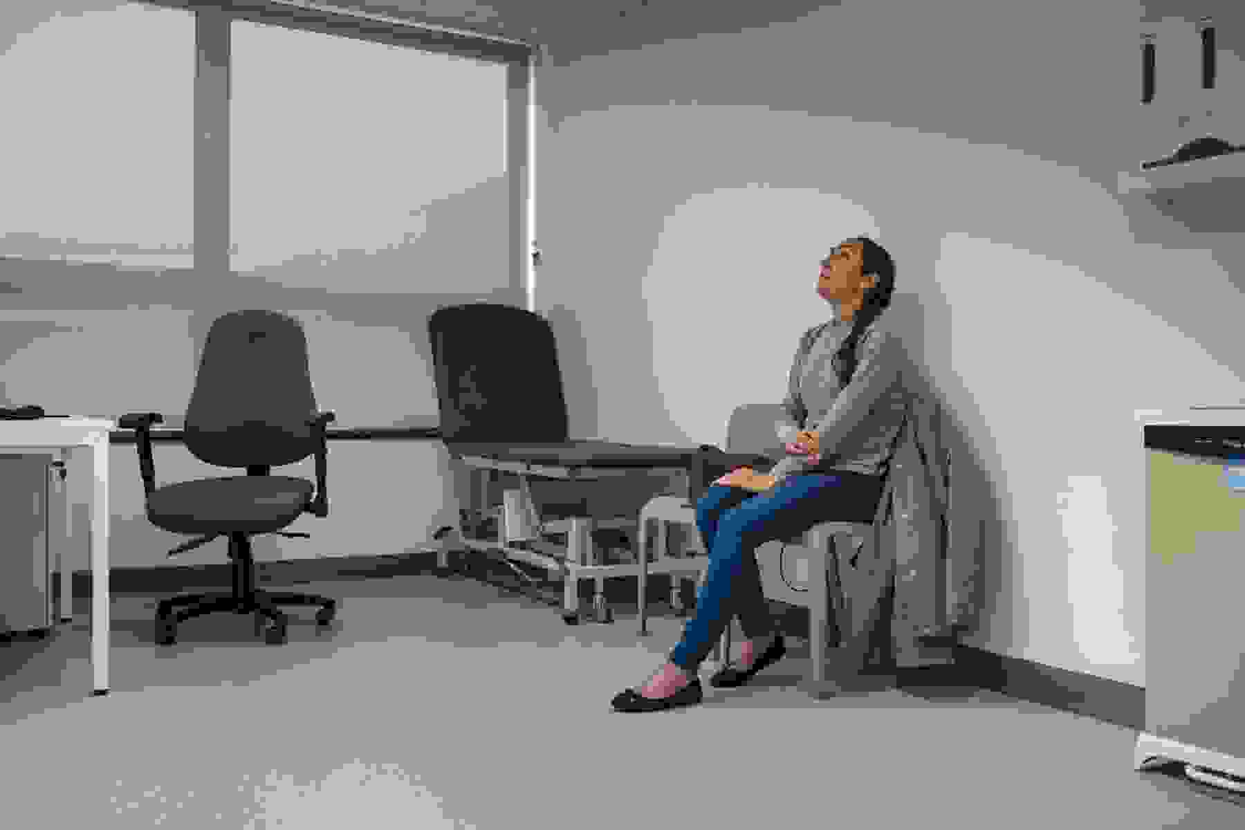 A woman waiting in a doctor's examination room waiting to be seen