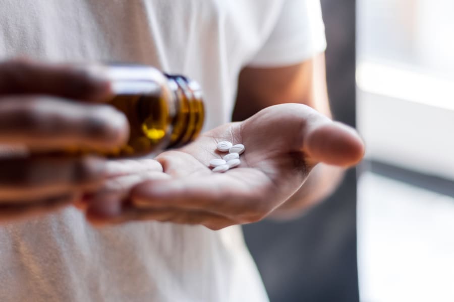 A person counting out their pills