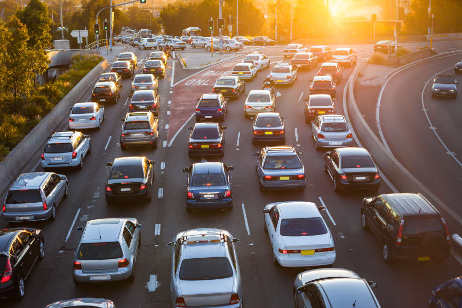 Cars driving on freeway at sunset
