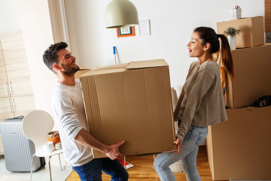 couple carrying property into new home