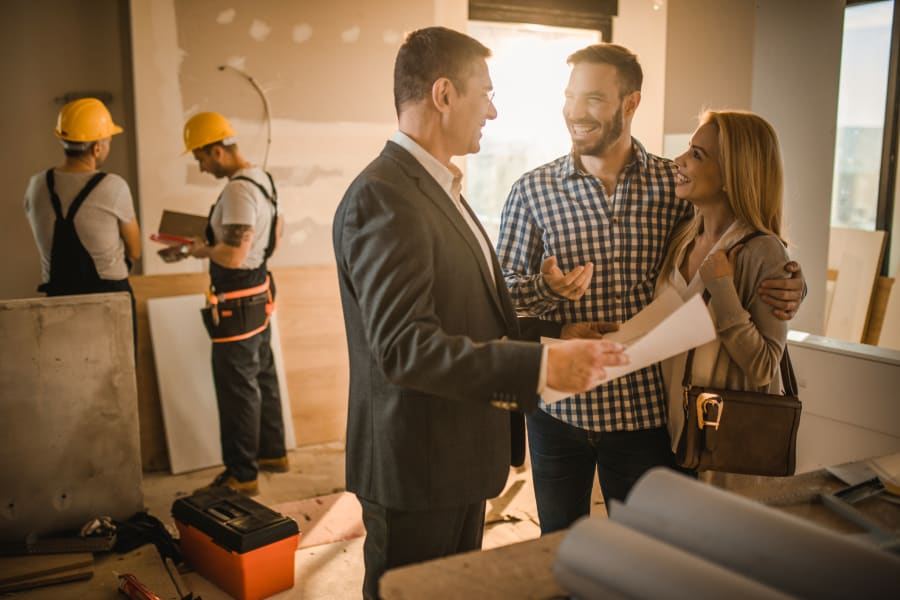 couple speaking with contractor about work on their home