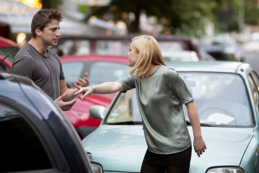Man and woman arguing after a traffic accident