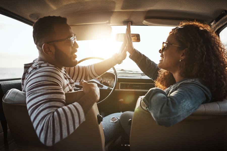 couple high fiving in their car