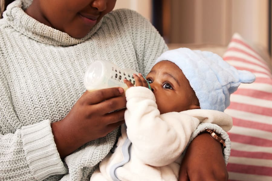 A baby drinks from a bottle.
