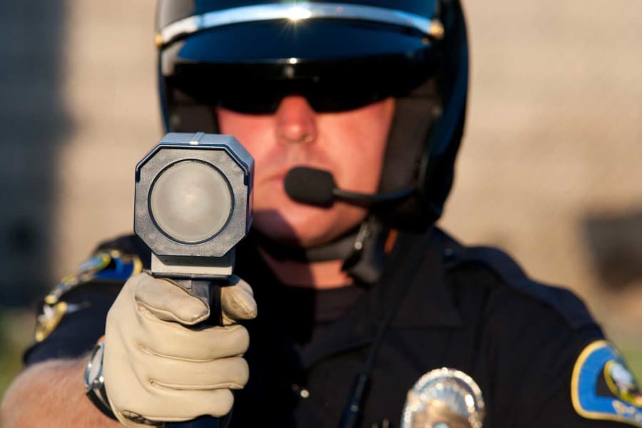 Officer using a speeding detection device.