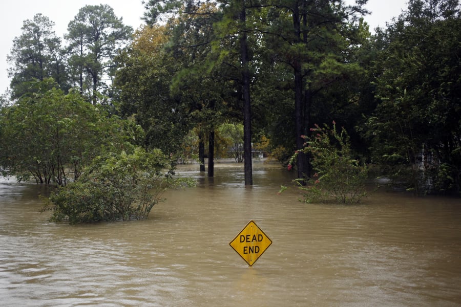 A Dead End sign stands in floodwaters.