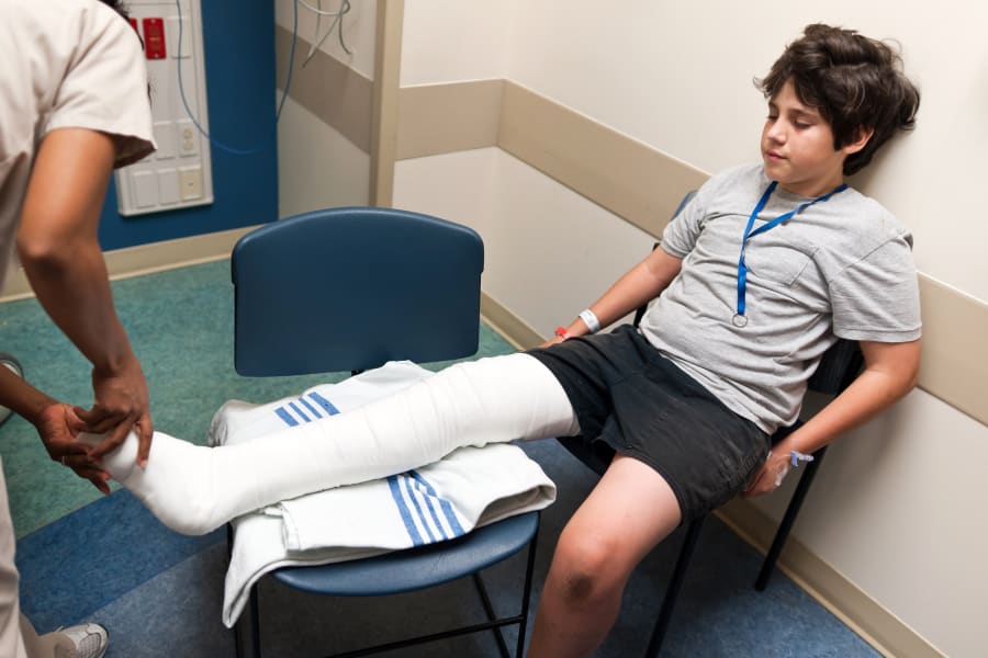 A nurse checks a child’s bandages.