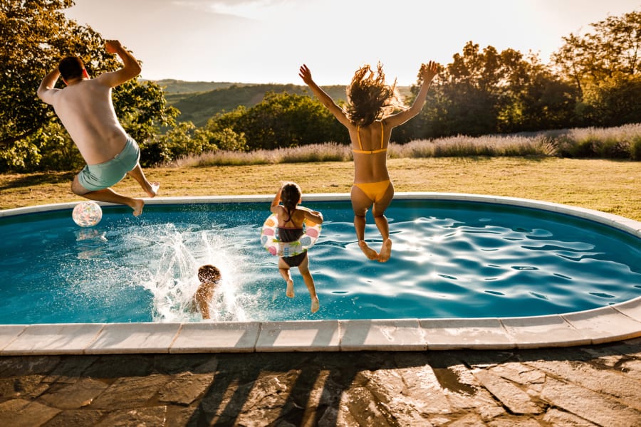 A family jumps into a pool.