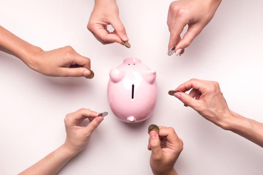 Hands putting coins in a piggybank