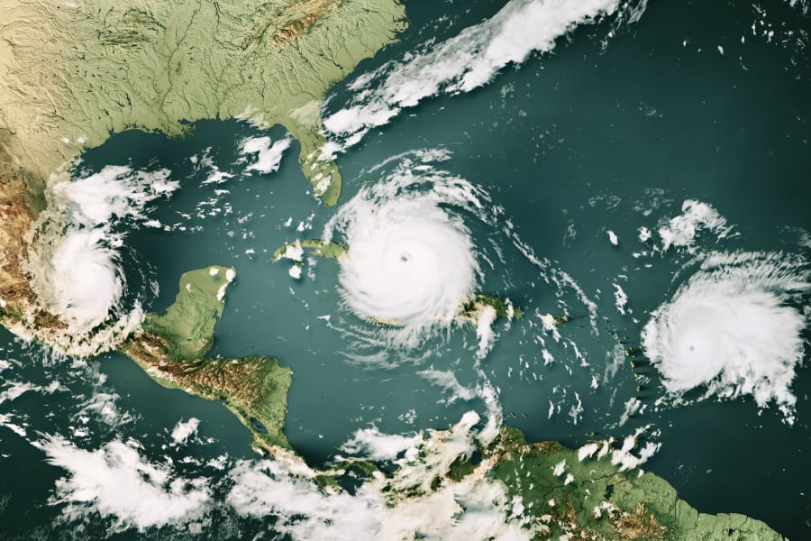 Three hurricanes over a map of the Caribbean Sea