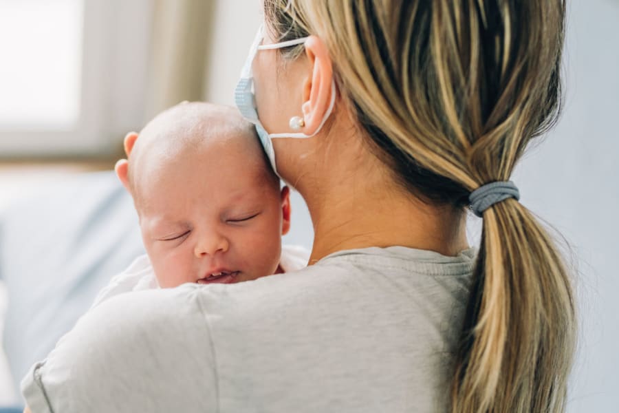 Mother with mask and newborn.