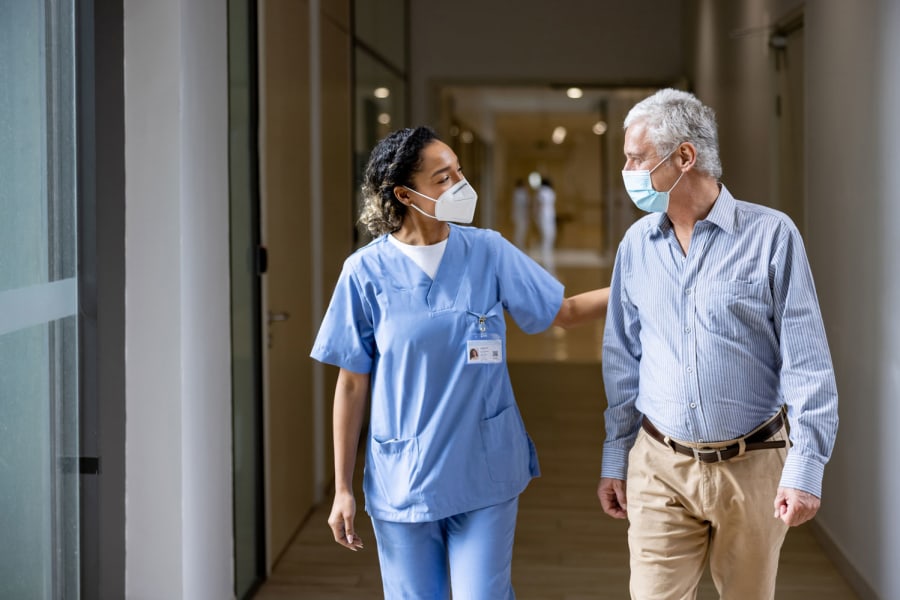 Nurse walking with an elderly patient.