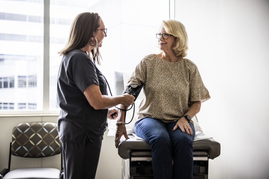 Nurse taking a senior woman's blood pressure