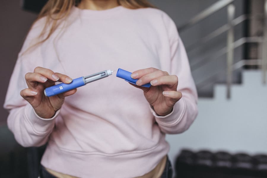 A woman prepares her weight-loss injection pen.