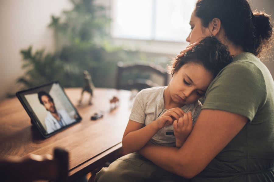 A mother utilizes a telehealth service.