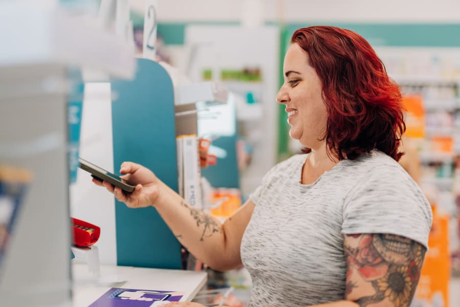 Plus size woman at payment counter with smartphone