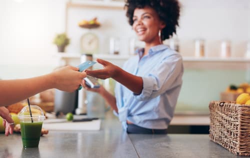 small business cashier takes credit card from customer
