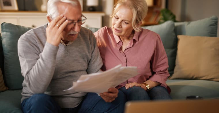Senior couple analyzes healthcare bills.