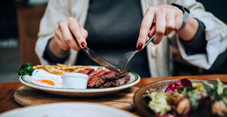 Diner enjoying a steak dinner.