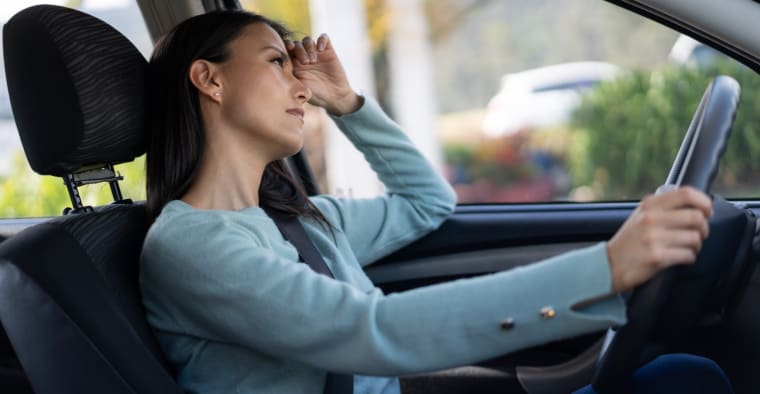 A thoughtful woman in her car