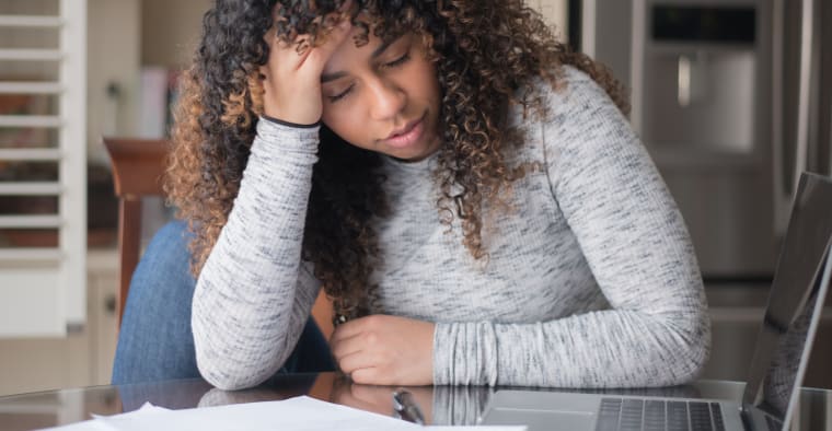A stressed woman looking at bills